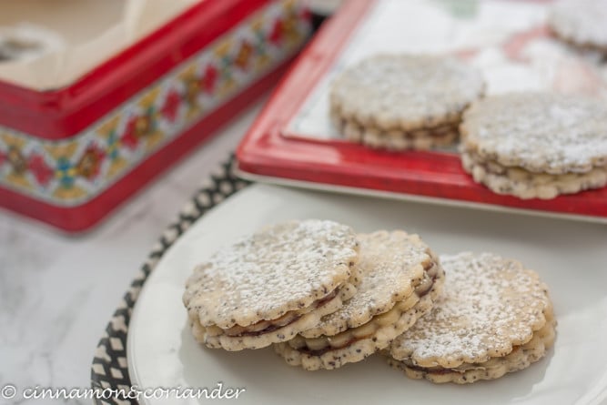 three poppy seed cookies with marzipan and plum jam