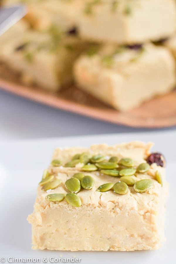 side view close-up of a vegan chickpea blondie topped with toasted pumpkin seeds