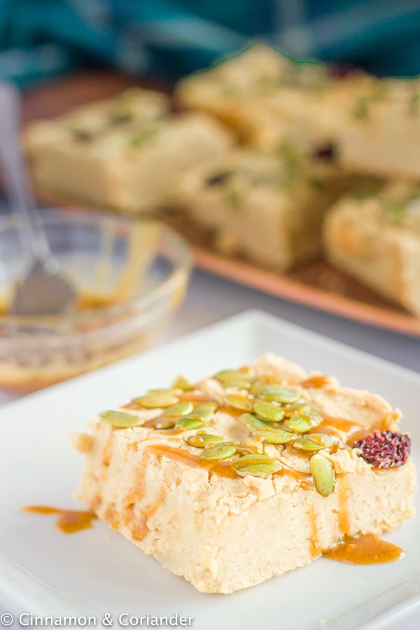 a vegan chickpea blondie topped with toasted pepitas and pumpkin caramel sauce
