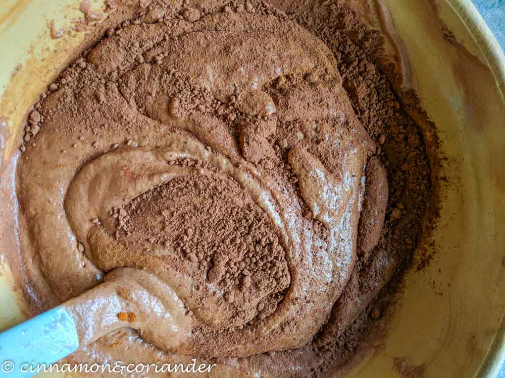 cocoa powder being folded into vegan sugar free chocolate mousse