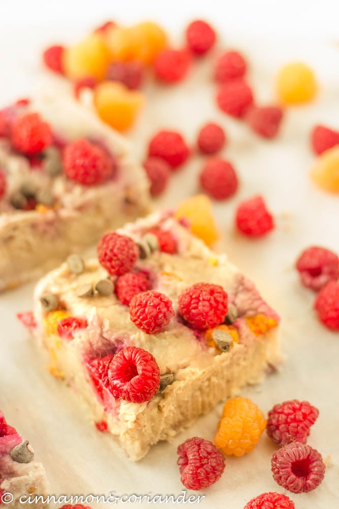 Vegan Raspberry Blondies cut into squares and served with fresh raspberries
