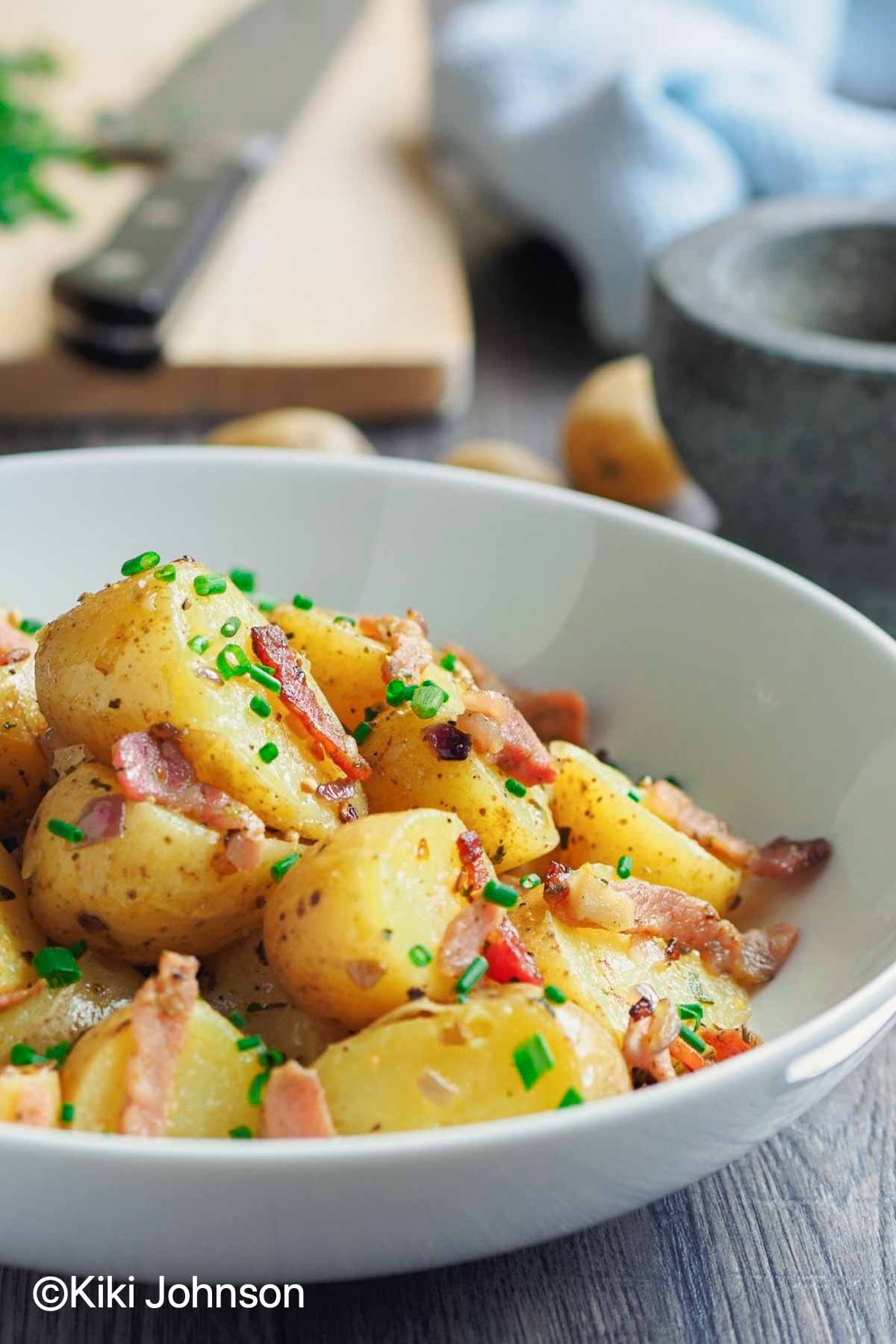 warm Bavarian Potato Salad with bacon served in a small white bowl 