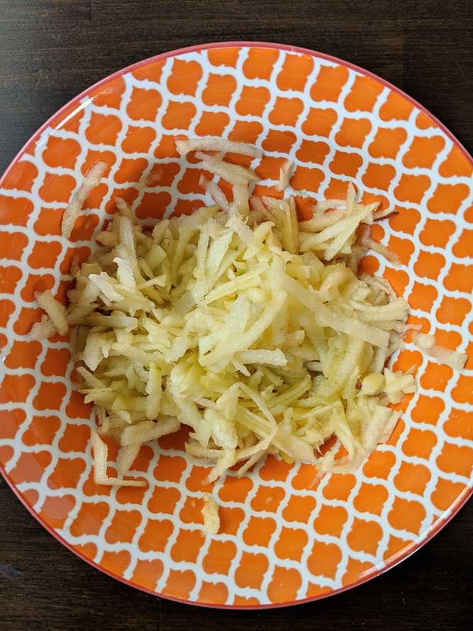 grated apples in an orange bowl