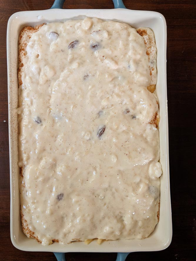 Casserole filled with raisin studded old fashioned rice pudding ready to be baked
