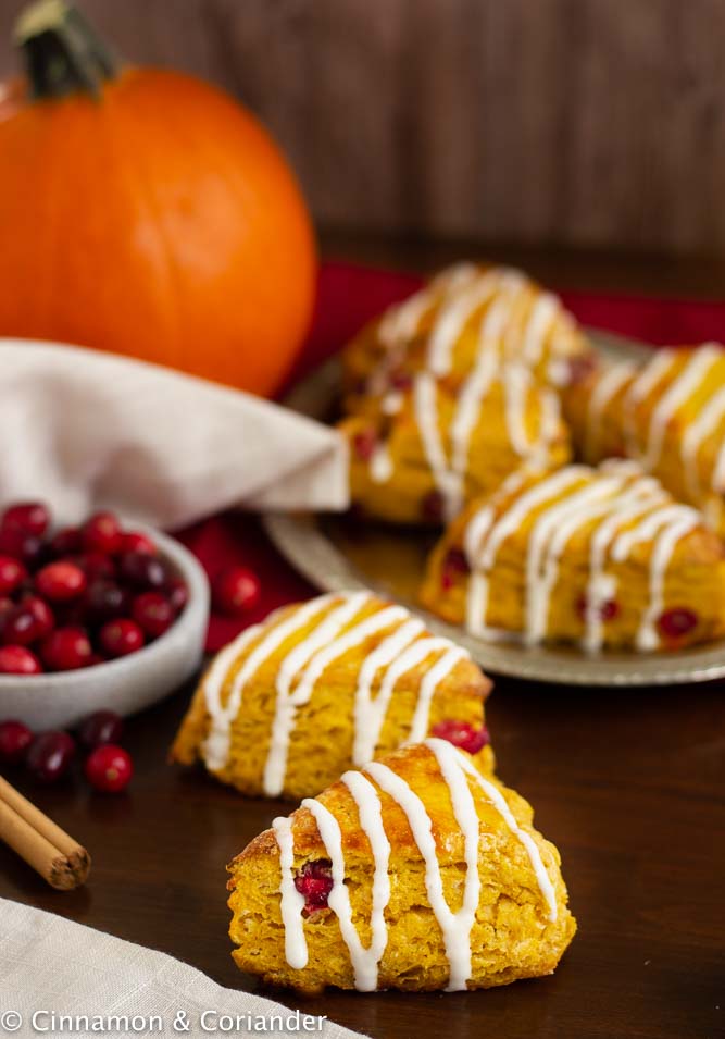 saftige Kürbis Scones mit frischen Cranberries und Frischkäse Glasur auf einer rustikalen herbstlich dekorierten Kuchentafel