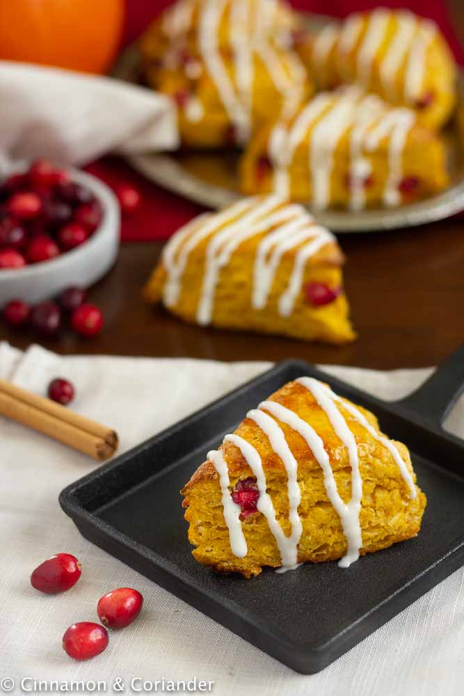 Starbucks Kürbis Scone mit frischen Cranberries und Frischkäseglasur angerichtet auf einer herbstlichen Kaffeetafel