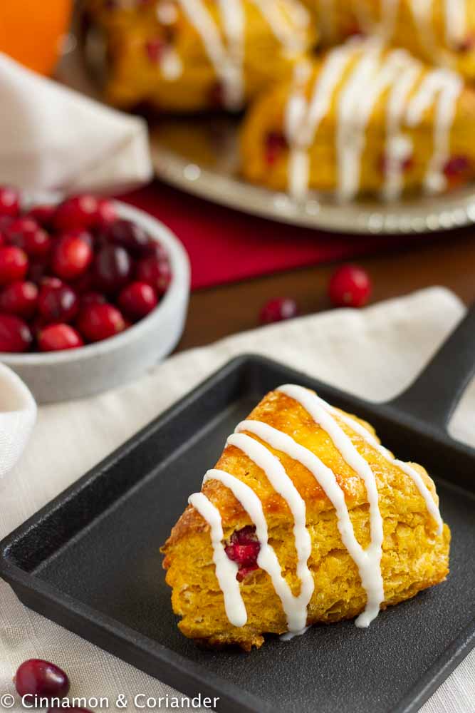 Saftige Kürbis Scones mit frischen Cranberries und Frischkäse-Glasur auf einer herbstlichen Tafel 