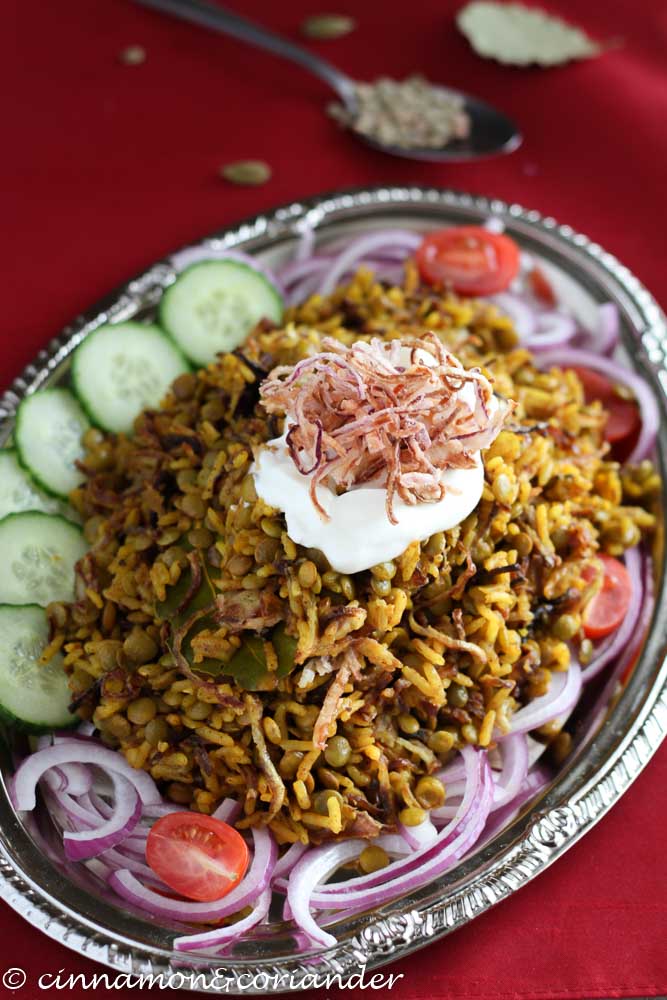 Mujaddara Arabische Linsen mit Reis und frittierten Zwiebeln auf einer silbernen Platte mit veganem Kokosjoghurt servierrt