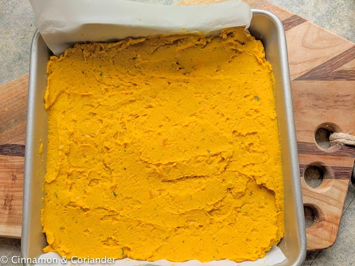 vegan pumpkin bar batter being spread into a square baking pan