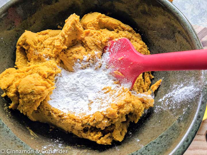 gluten-free baking powder being stirred into pumpkin bar batter