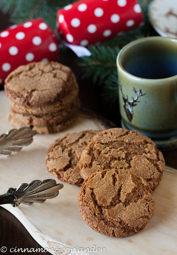 bacon fat gingersnap cookies on a wooden board with presents in the background