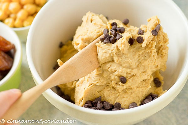 dark chocolate chips being folded into healthy vegan cookie dough