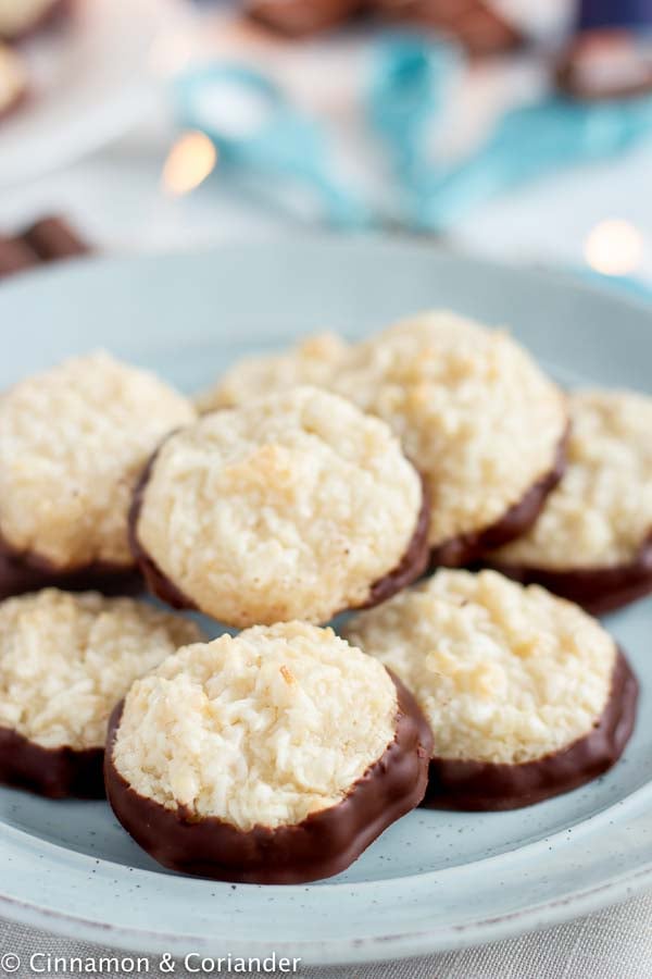 easy moist coconut macaroons with dark chocolate on a pale blue plate