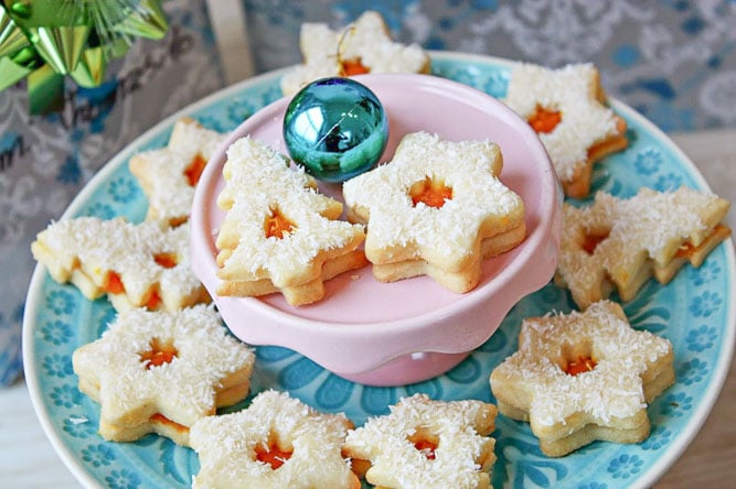 a platter with pumpkin linzer cookies with icing