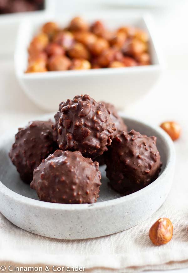 side view of a bowl of vegan healthy Ferrero Rocher Balls in a grey dish