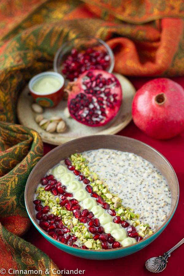 a bowl of Healthy Vegan Overnight Oats with Pistachio Creme, Rosewater and Pomegranate Seeds