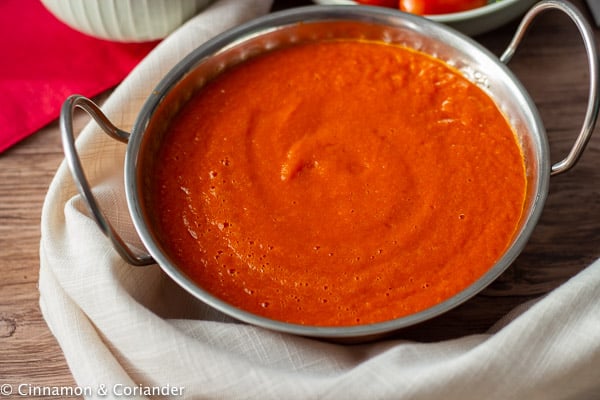 vegan roasted red pepper sauce served in a silver sauce dish