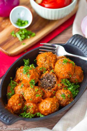 Healthy Vegan Meatballs with Black Beans with roasted bell pepper sauce in a black dish