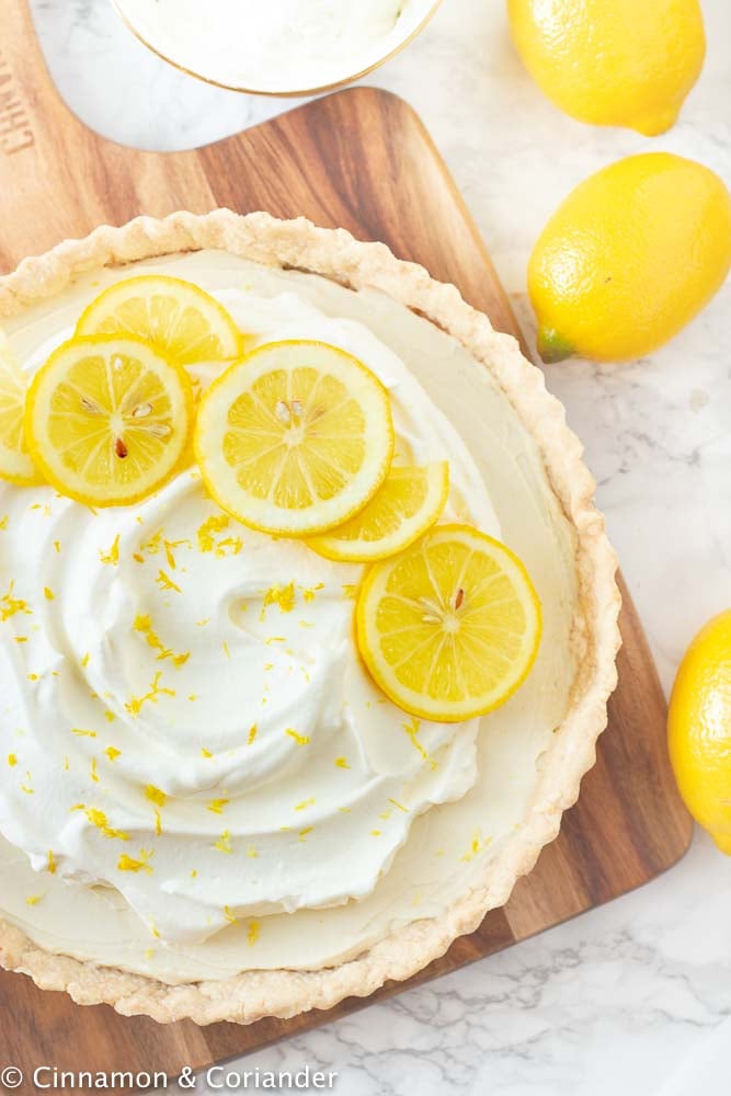 Easy Vegan Lemon Tart with Coconut Crust and Coconut Whipped Cream on a wooden board
