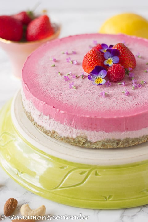 side-view of vegan no-bake strawberry cheesecake on a cake platter