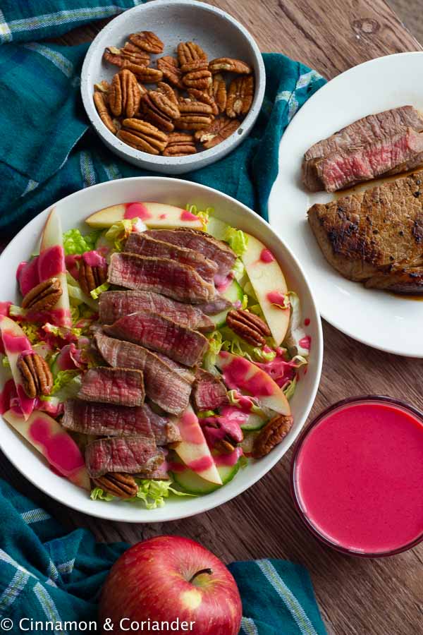 overhead shot of healthy autumn steak salad drizzled with maple raspberry vinaigrette