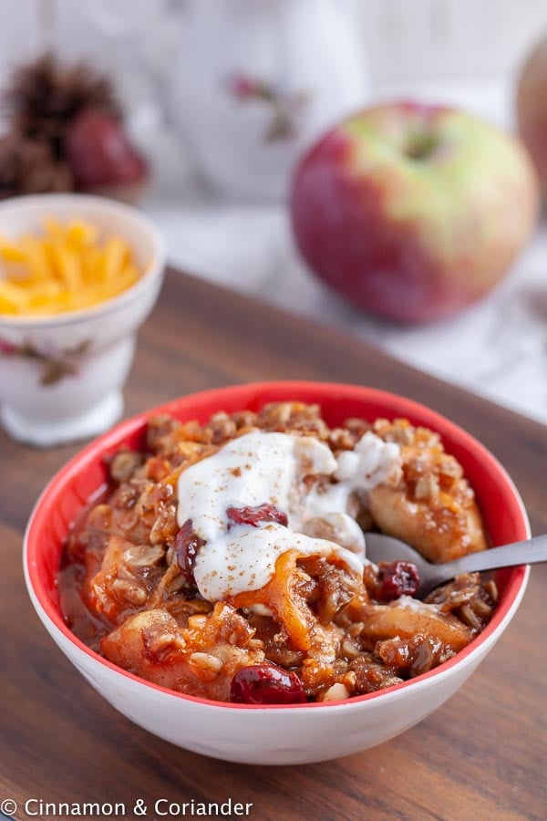 side view of a bowl of the best sugar-free apple crisp ever with cheddar cheese topping 
