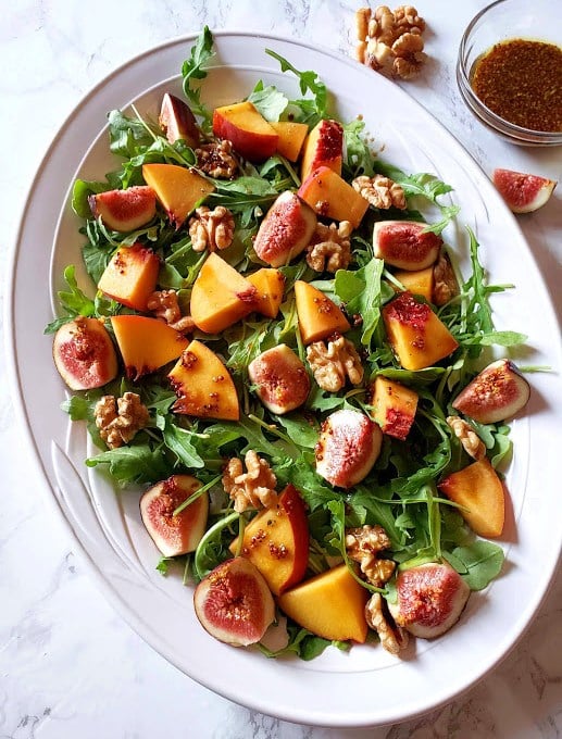Arugula Salad with fresh figs, peaches and walnuts with a small dish of maple vinaigrette on the side
