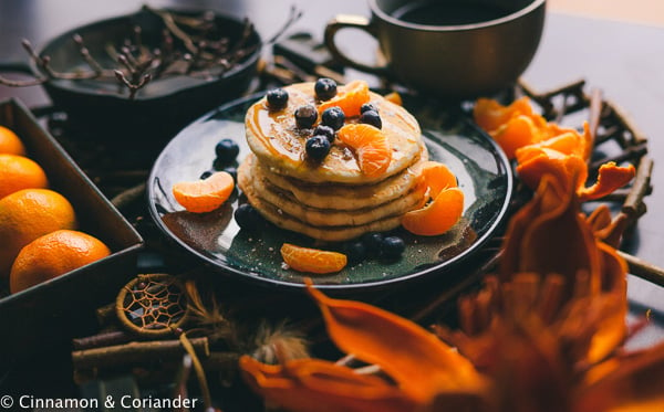gesunde vegane Pfannkuchen mit Blaubeeren und selbstgemachtem Mandarinen Pancakes Sirup auf einer weihnachtlichen Frühstückstafel