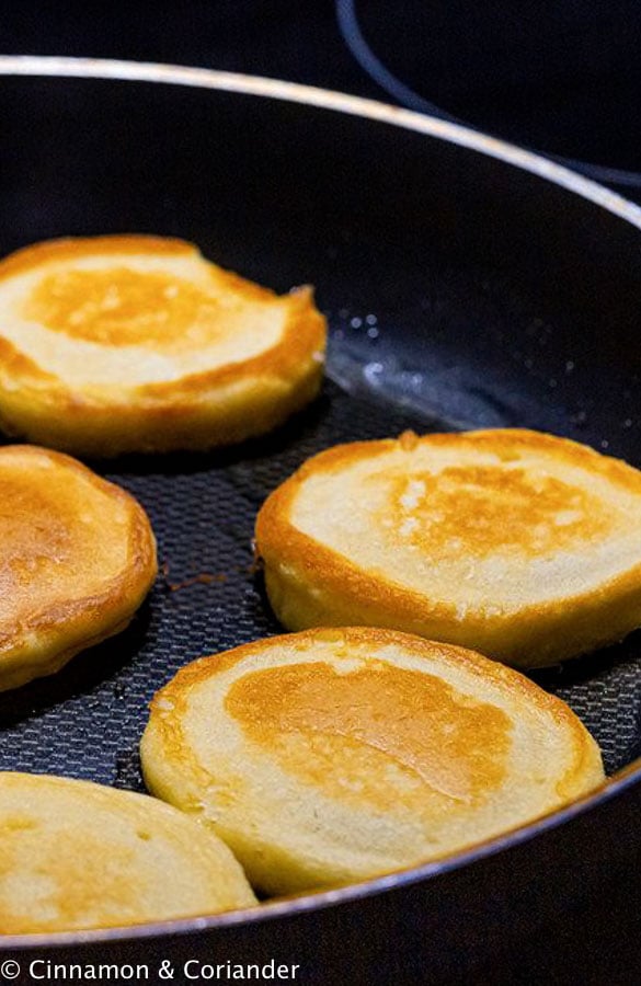 fluffy vegan pancakes with almond milk frying in a skillet 