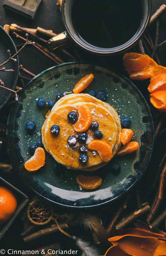 Ein Stapel Veganer Pfannkuchen mit Zimt Mandarinensirup und Blaubeeren serviert
