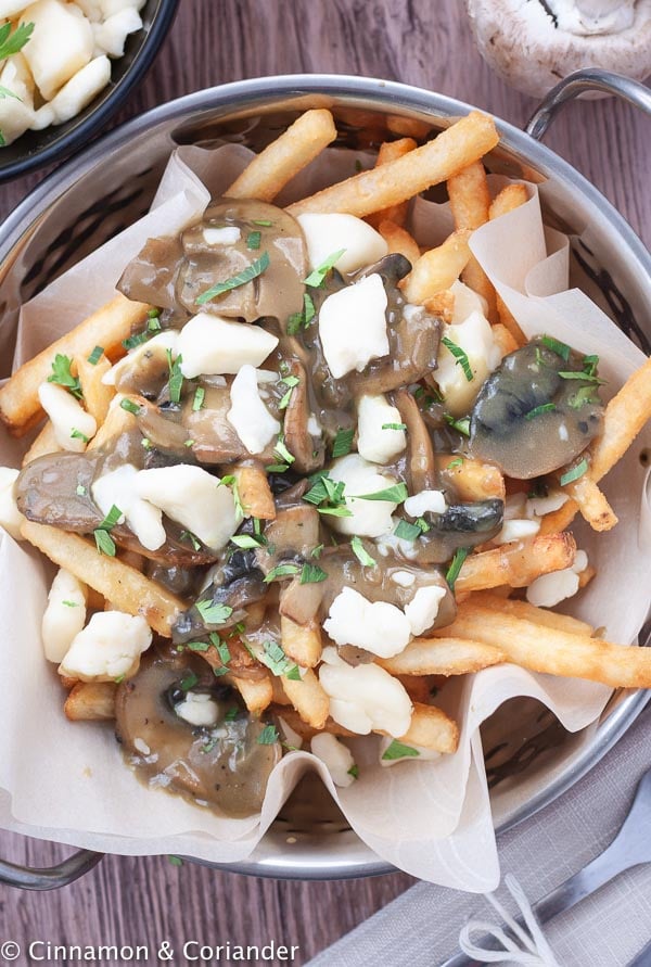 overhead shot of authentic Canadian Poutine with vegetarian Mushrooms Gravy