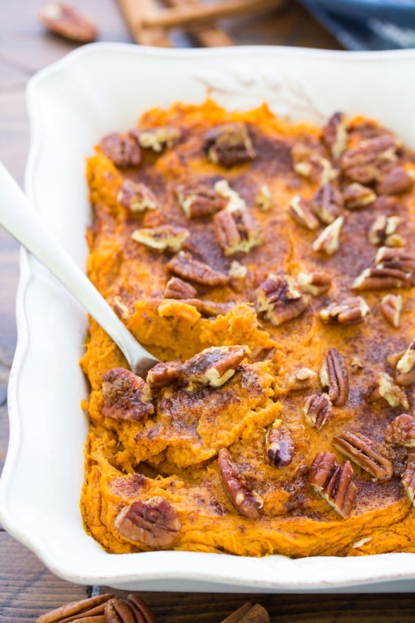 healthy sweet potato casserole topped with pecans 