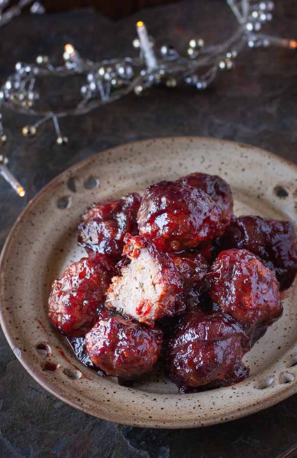 side view of a plate of healthy baked turkey meatballs smothered in paleo cranberry sauce