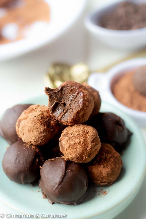 healthy vegan rum balls piled up on a pale blue plate