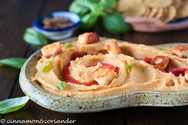 side view of a stone platter with sweet potato hummus served as a hummus bowl with healthy toppings