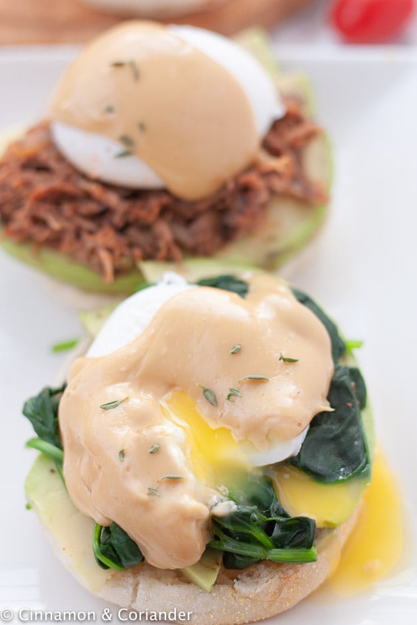 overhead shot of eggs benedict served with runny yolks and homemade espresso hollandaise over an English muffin