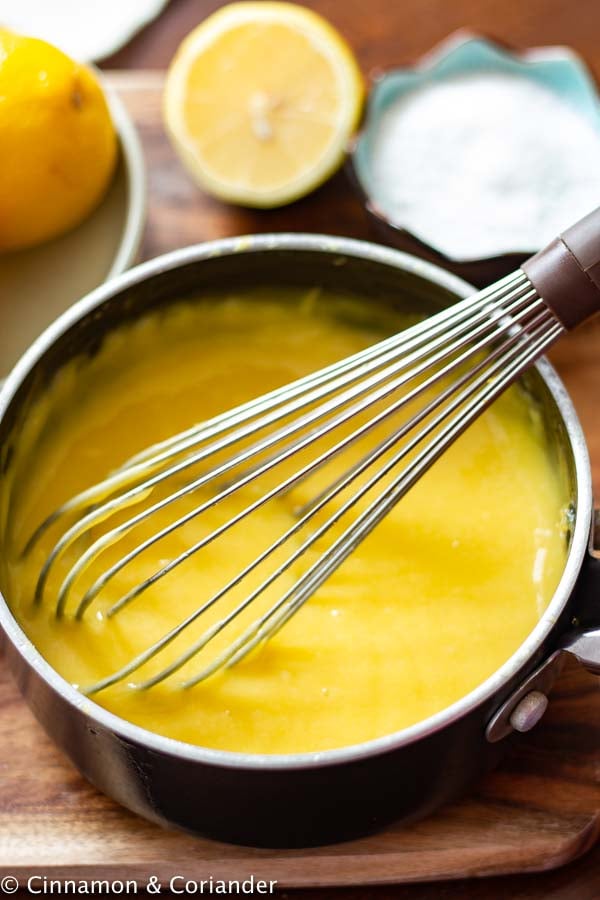sugar free lemon curd being whisked in a saucepan until thick 
