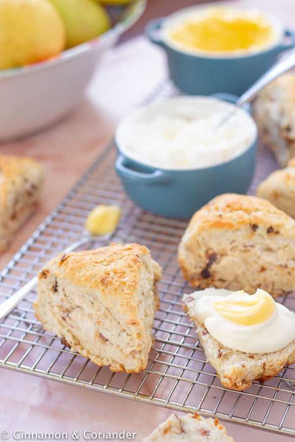 fluffy vegan scones on a cooling rack served with a side of lemon curd and vegan clotted cream