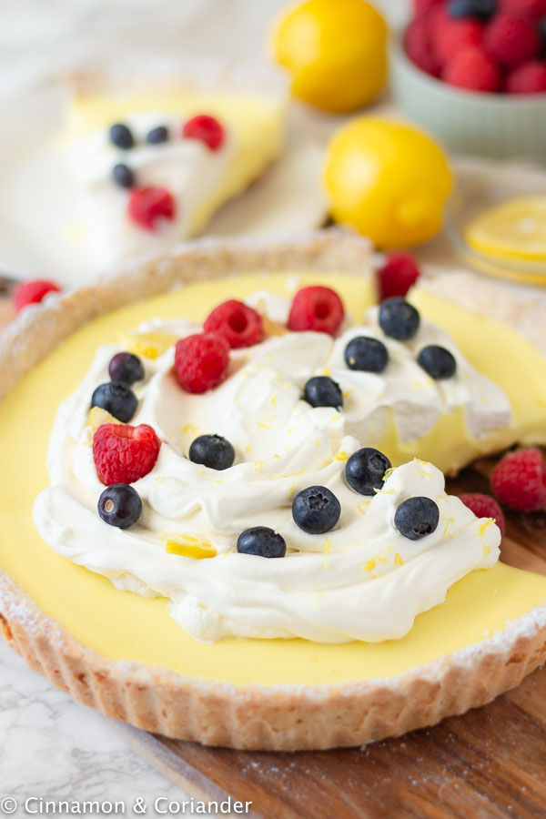 a classic French Lemon Tart topped with whipped cream and fresh berries