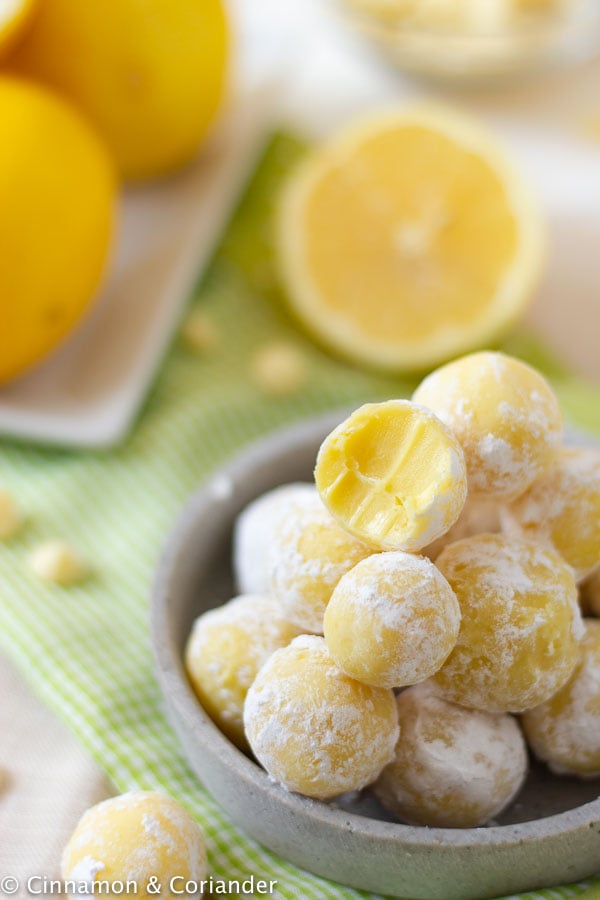 lemon white chocolate truffles rolled in powdered sugar on a small plate