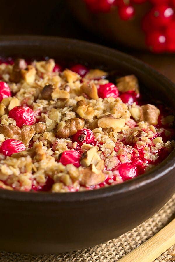 side view of a serving of vegan red currant crumble with walnut oat topping 