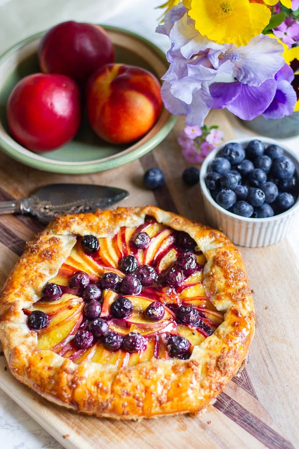 overhead shot of a rustic French Nectarine Blueberry Galette on a wooden board