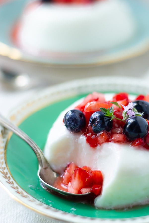 Joghurt Panna Cotta nach italienischen Rezept serviert mit frischen marinierten Beeren und Thymian