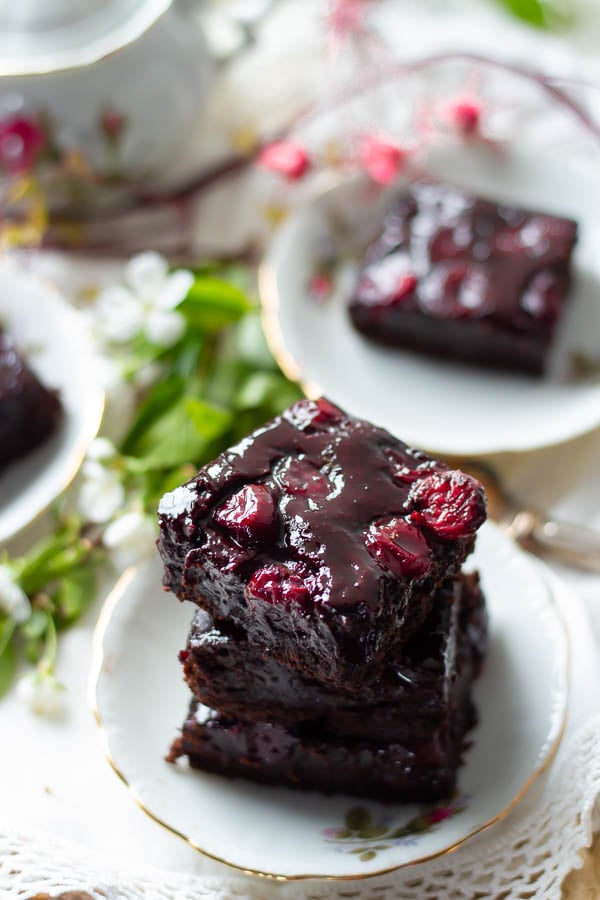 overhead shot of three stacked brandy cherry brownies with cocoa powder