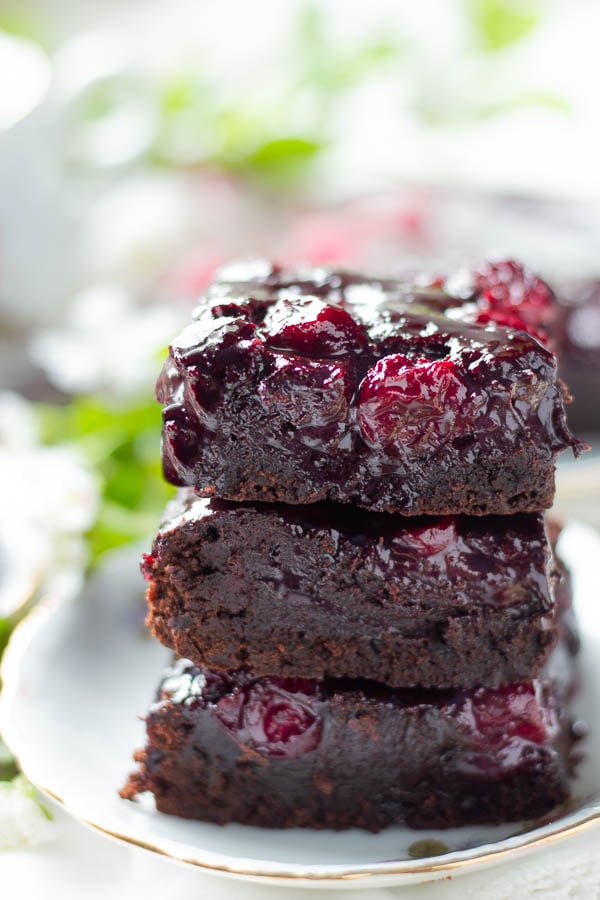 a stack of easy brandy cherry brownies with cocoa powder glazed with brandy caramel