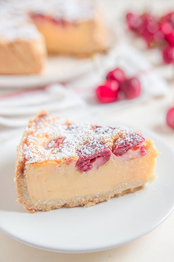 a slice of German sour cherry custard pie dusted with icing sugar 