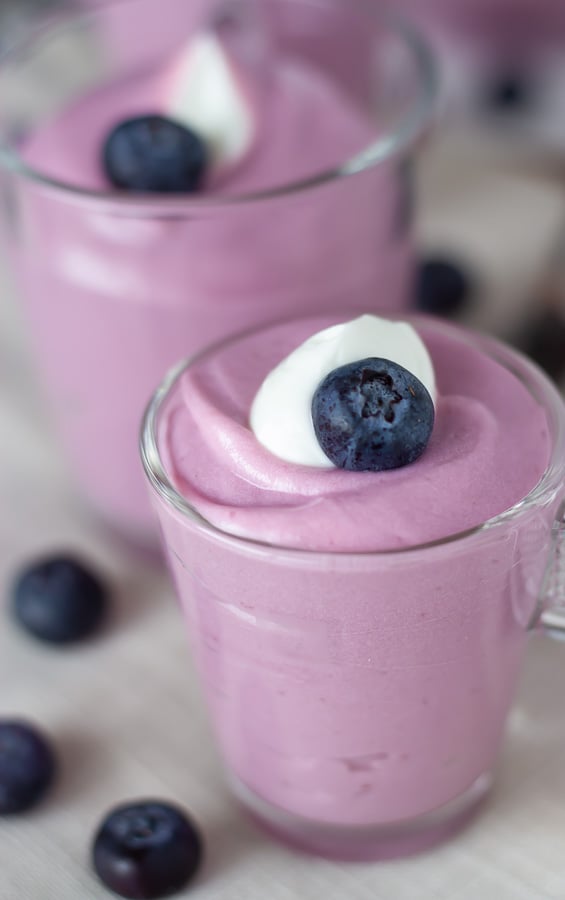 side view of healthy no bake vegan blueberry cheesecake mousse in two jars 