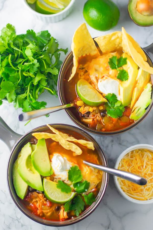 overhead shot of two bowls of cheesy authentic Mexican Chicken Tortilla Soup with toppings