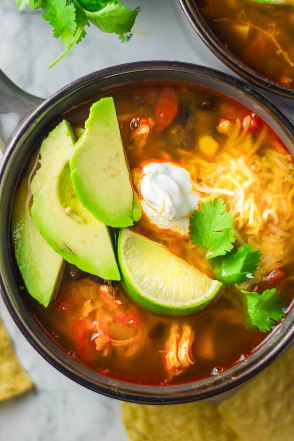 a bowl of homemade authentic Mexican chicken tortilla soup with avocado slices