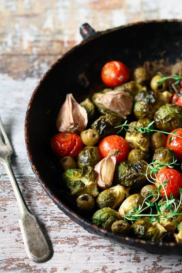 a skillet with balsamic roasted brussel sprouts with tomatoes and garlic 